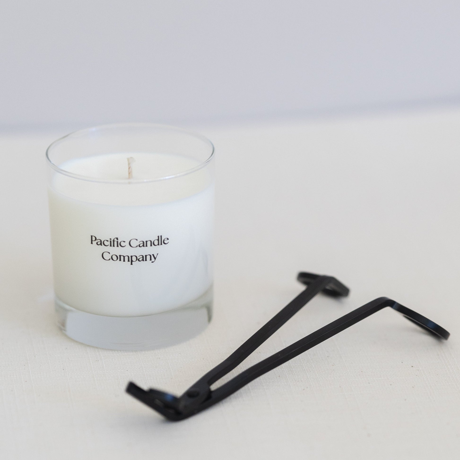 A single wick soy candle in a sleek glass jar, hand-poured with toxin-free wax and a cotton braided wick for a clean, even burn. Perfect for adding a warm glow and a subtle fragrance to any room. Scent: Fir Needle + Rhubarb.