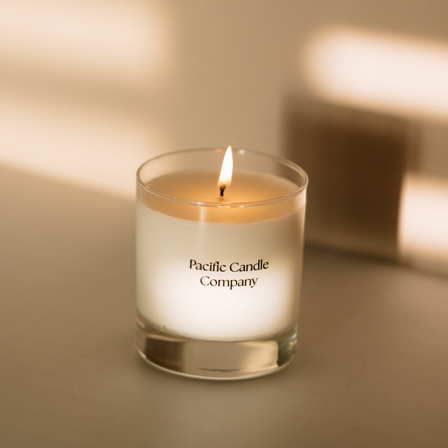 A single wick soy candle in a sleek glass jar, hand-poured with toxin-free wax and a cotton braided wick for a clean, even burn. Perfect for adding a warm glow and a subtle fragrance to any room. Scent: Amber + Orange Clove.