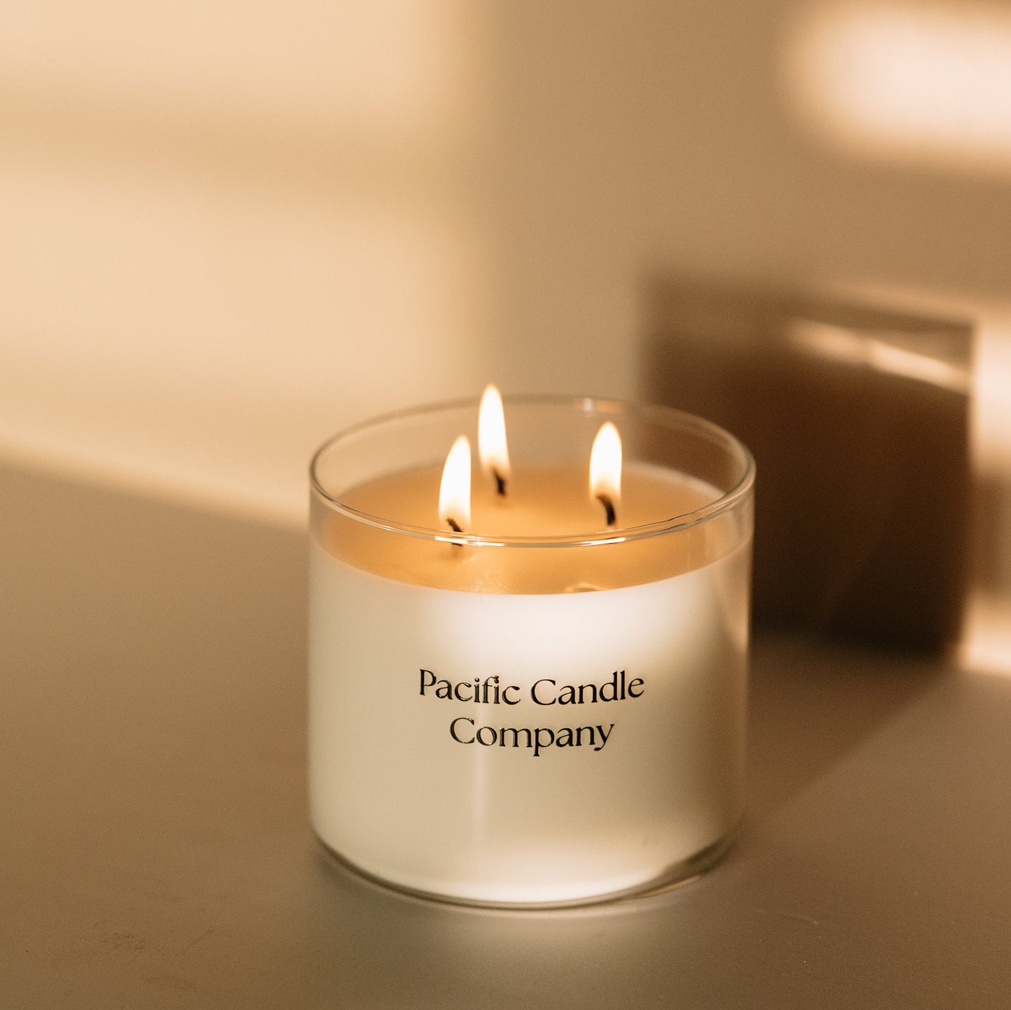 A luxurious triple wick soy candle in a wide, elegant glass vessel, crafted for a long-lasting burn and a bold, even scent throw. Designed to elevate the ambiance of larger spaces with its sophisticated look and fragrance. Scent: Amber + Orange Clove.