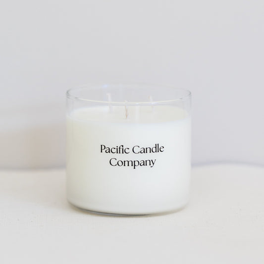 A luxurious triple wick soy candle in a wide, elegant glass vessel, crafted for a long-lasting burn and a bold, even scent throw. Designed to elevate the ambiance of larger spaces with its sophisticated look and fragrance. 