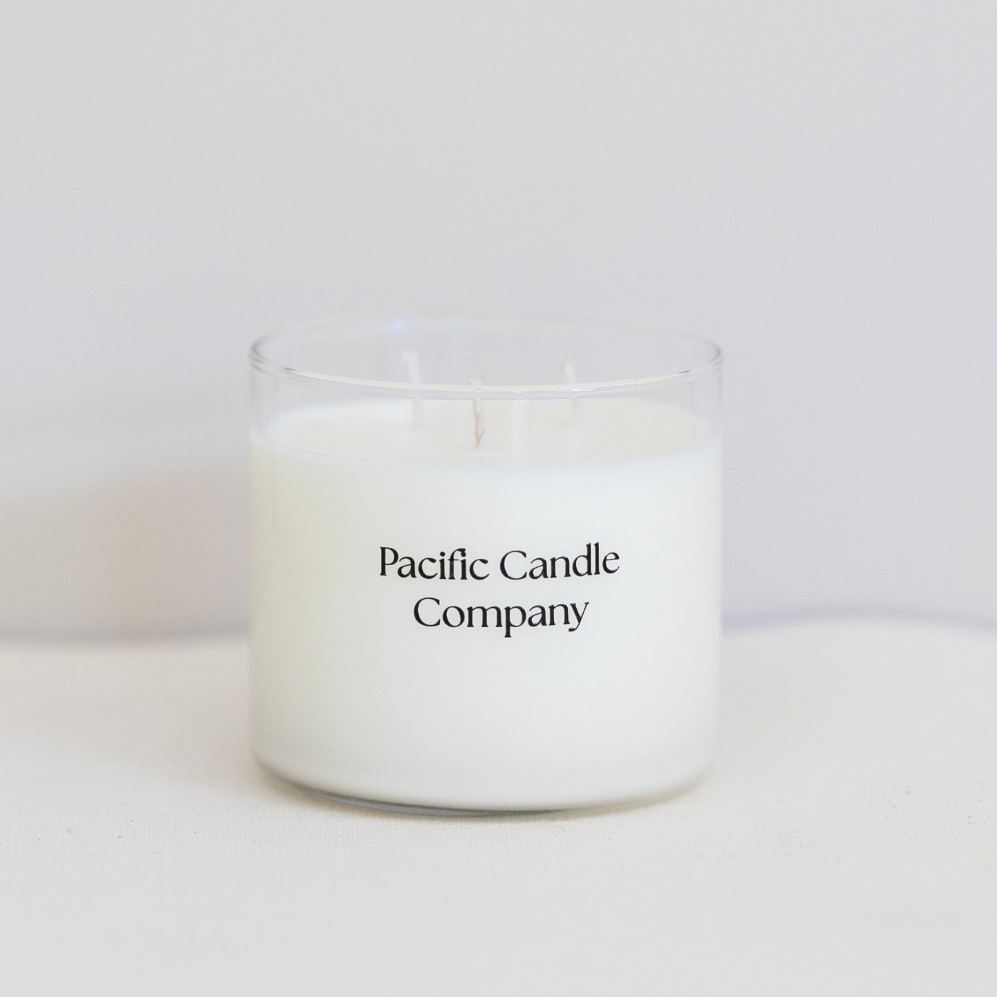 A luxurious triple wick soy candle in a wide, elegant glass vessel, crafted for a long-lasting burn and a bold, even scent throw. Designed to elevate the ambiance of larger spaces with its sophisticated look and fragrance. Scent: Amber + Orange Clove.